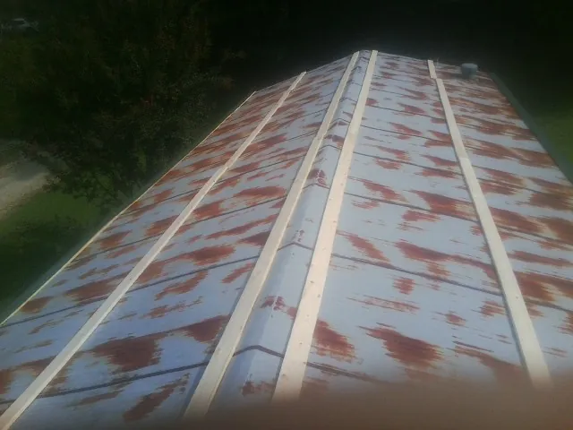 Rusted metal roof panels with new wood purlins before replacement — Storm Damage Roof Repair in Osco by Roofing Brothers