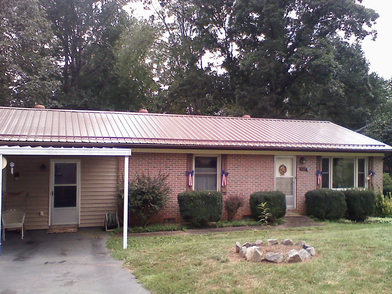 Bronze metal roof and carport on a brick ranch home — Roof Repair work by our crew in Osco