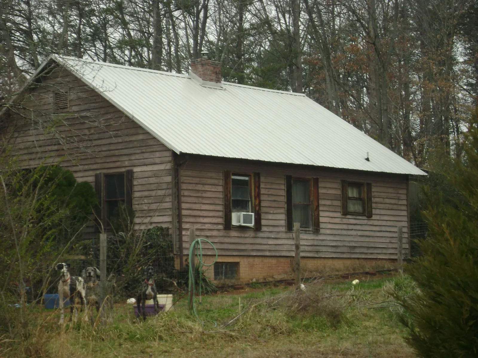 White metal roof on an old wood sided farmhouse, from a Metal Roof Installation job in Osco